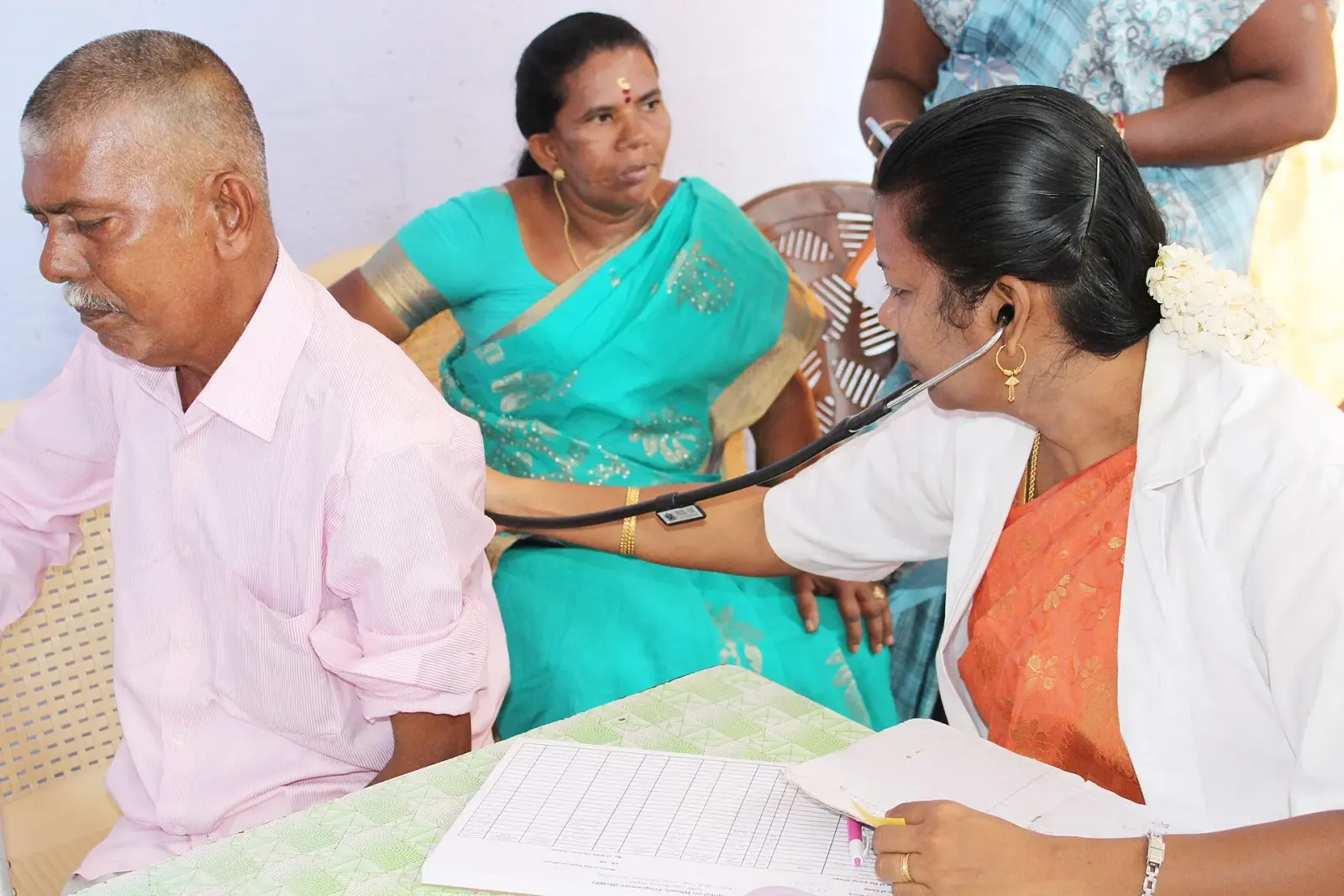 A doctor checking an elderly man's blood pressure